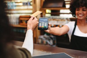 Helpful in-store associates offer wireless payment device for customers to complete their purchases.