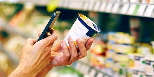 Woman using Mercatus Picker App on a phone to scan a yoghurt